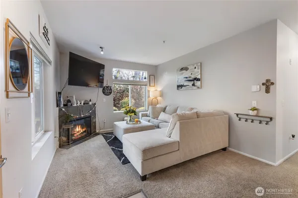 a living room with furniture a fireplace and a large window