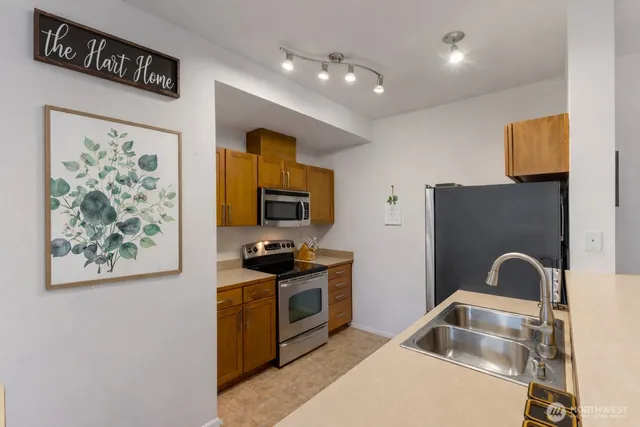 a kitchen with stainless steel appliances granite countertop a stove a sink and a microwave