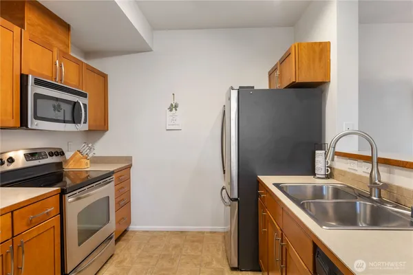 a kitchen with stainless steel appliances granite countertop a refrigerator and a sink