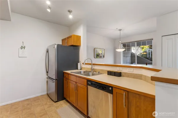 a view of a kitchen with a sink and a dishwasher with a large mirror