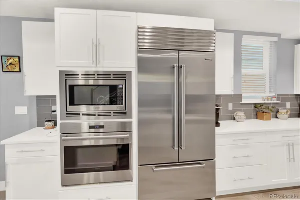 a kitchen with a refrigerator stove and cabinets