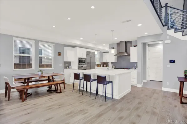 a kitchen with white cabinets and chairs