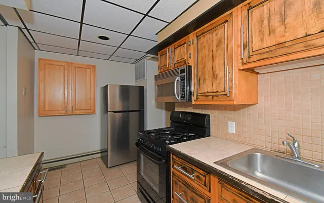 a kitchen that has a sink cabinets counter space and appliances