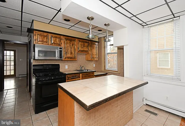 a kitchen with stainless steel appliances granite countertop a sink a stove and a refrigerator