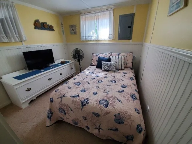a bedroom with a bed and flat screen tv