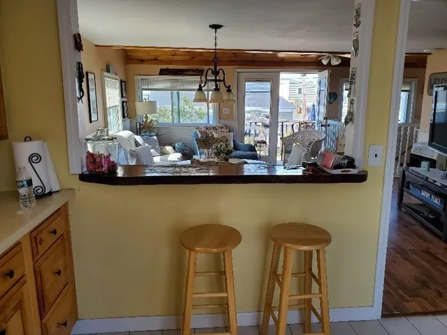 a room with chairs and view of kitchen