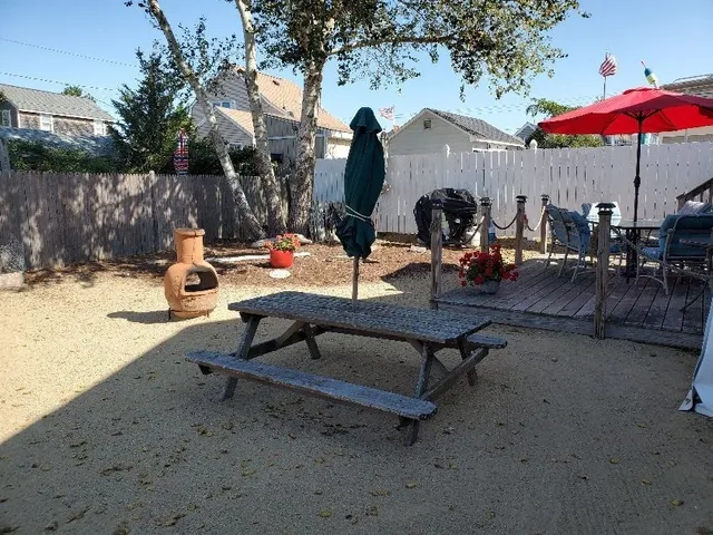 a view of a backyard with a table and chairs under an umbrella