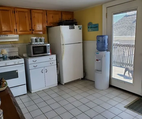 a kitchen with a refrigerator sink and cabinets