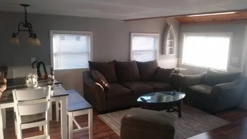 a living room with furniture a ceiling fan and a window