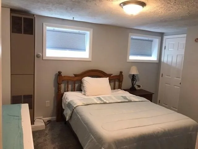 a large bed sitting in a bedroom next to a window