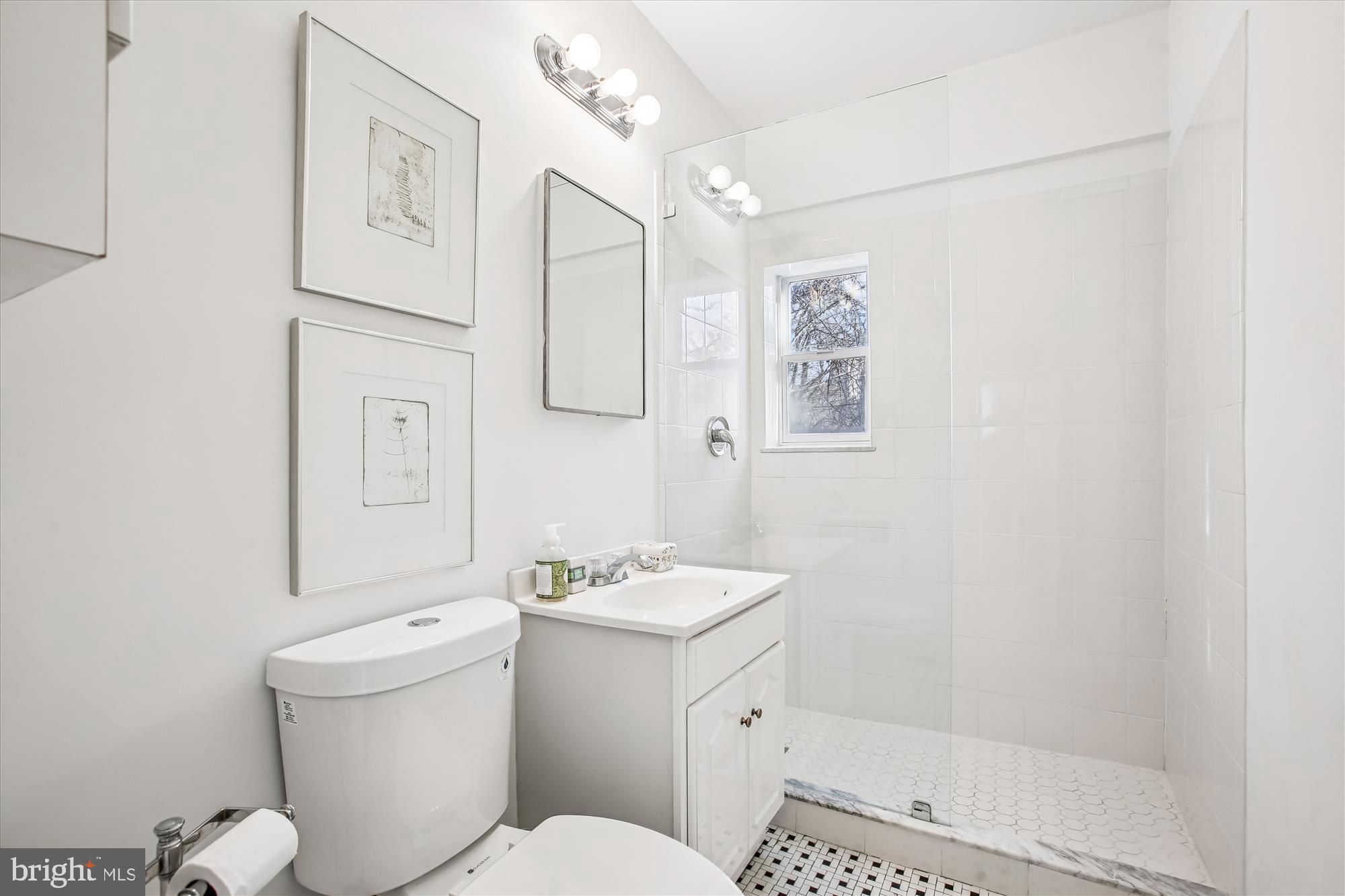 2500 Q Street Northwest, Unit 112 Washington, DC 20007 - Photo 16 of 19 a bathroom with a granite countertop sink mirror vanity and toilet