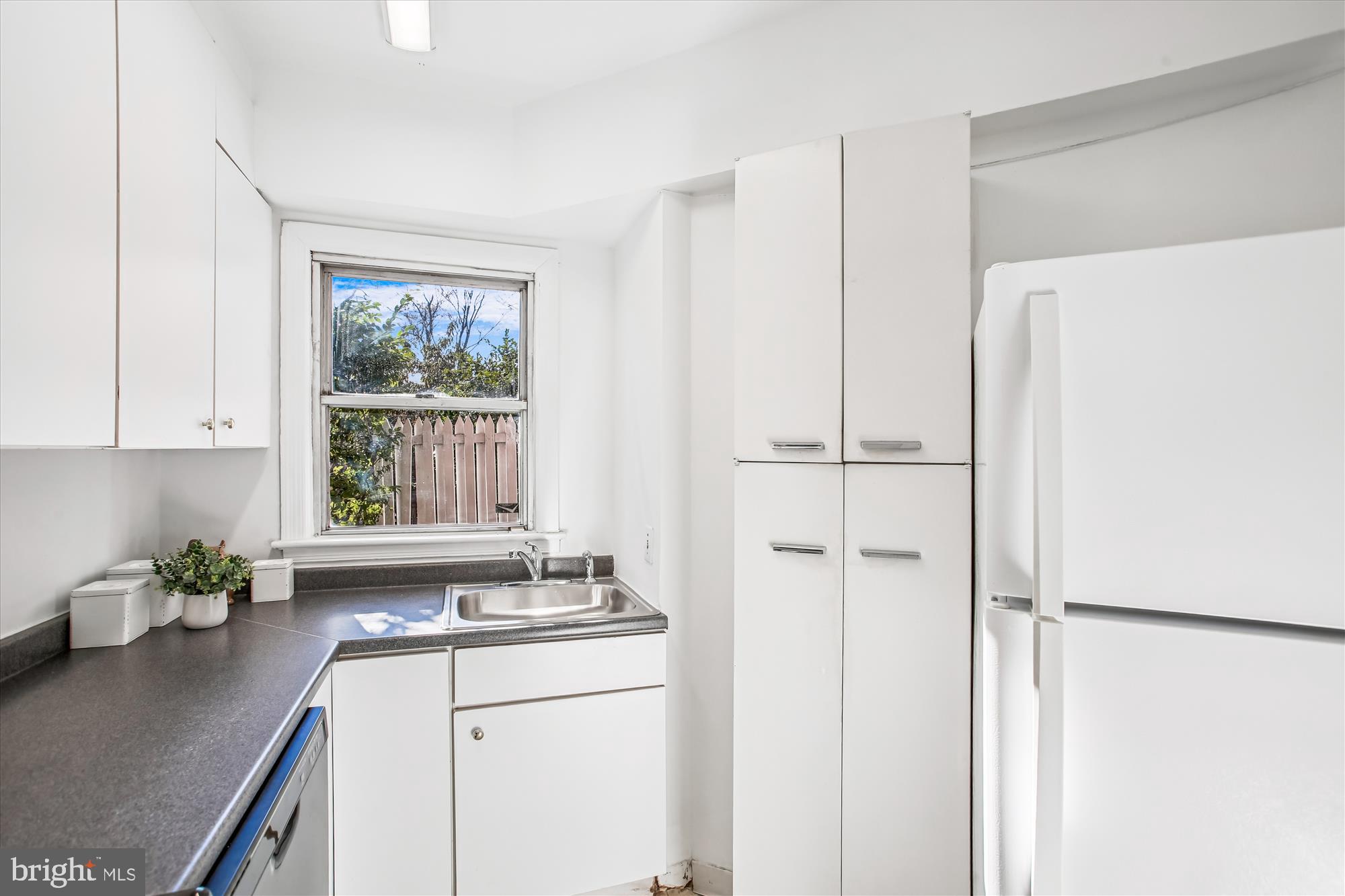 2500 Q Street Northwest, Unit 112 Washington, DC 20007 - Photo 10 of 19 a kitchen with a refrigerator sink and cabinets