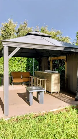 a view of a patio with table and chairs potted plants with wooden floor and fence