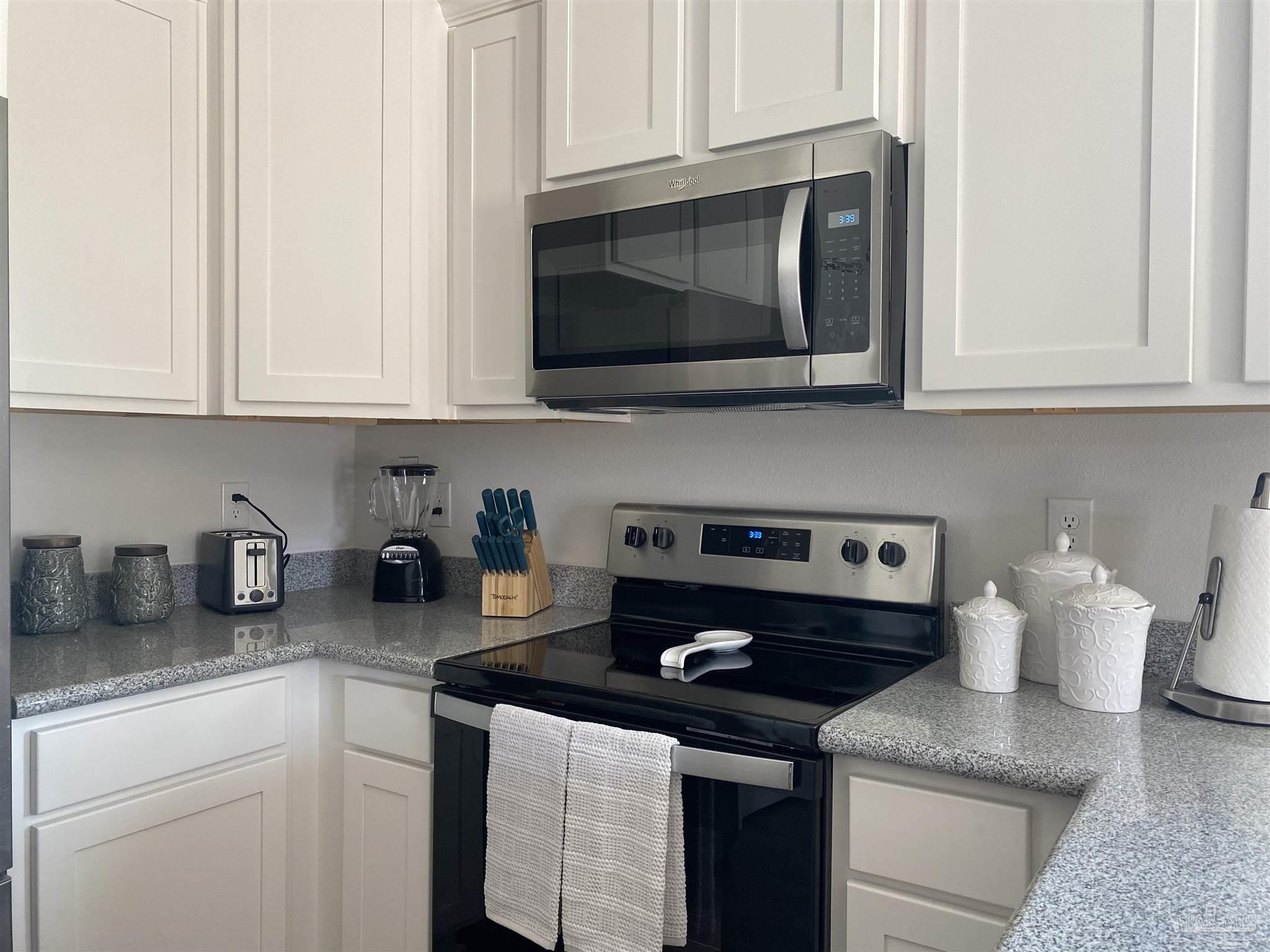 a kitchen with stainless steel appliances granite countertop a sink stove and microwave