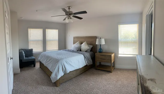 a spacious bedroom with a bed a chandelier and a window