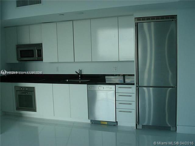 92 Southwest 3rd Street, Unit 2006 Miami, FL 33130 - Photo 6 of 13 a kitchen with a refrigerator and cabinets