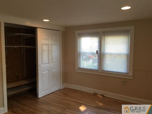 266 Raritan Boulevard Old Bridge, NJ 07735 - Photo 4 of 12 an empty room with wooden floor and windows