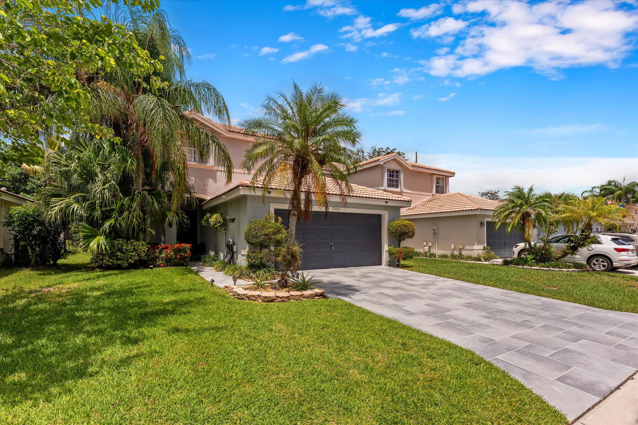 7061 Chesapeake Circle Boynton Beach, FL 33436 - Photo 2 of 51 a front view of a house with a yard and garage