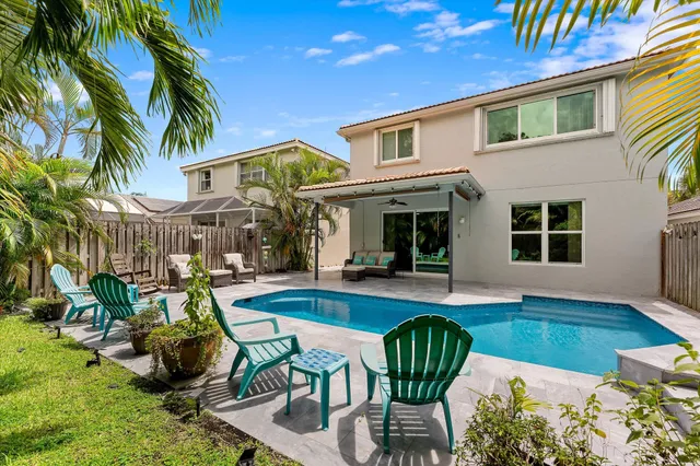 a view of a house with swimming pool and sitting area