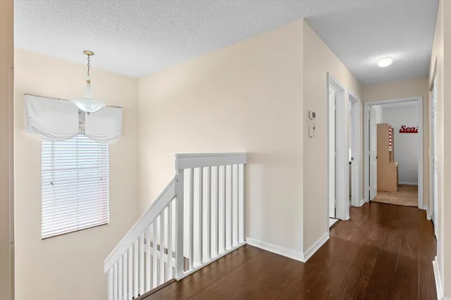 a view of hallway with windows and wooden floor