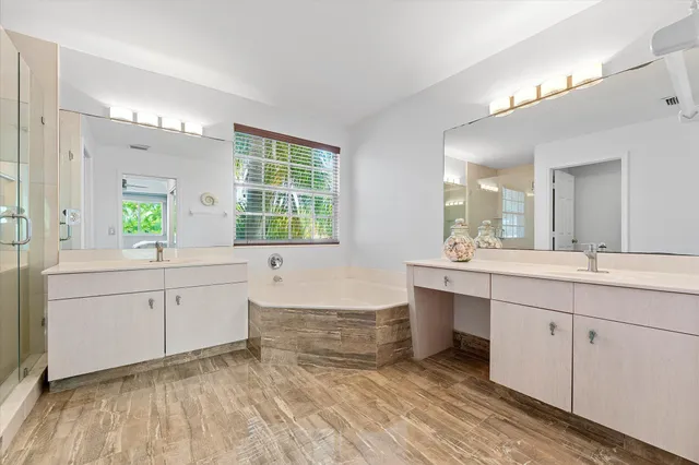 a spacious bathroom with a granite countertop sink mirror and a bathtub