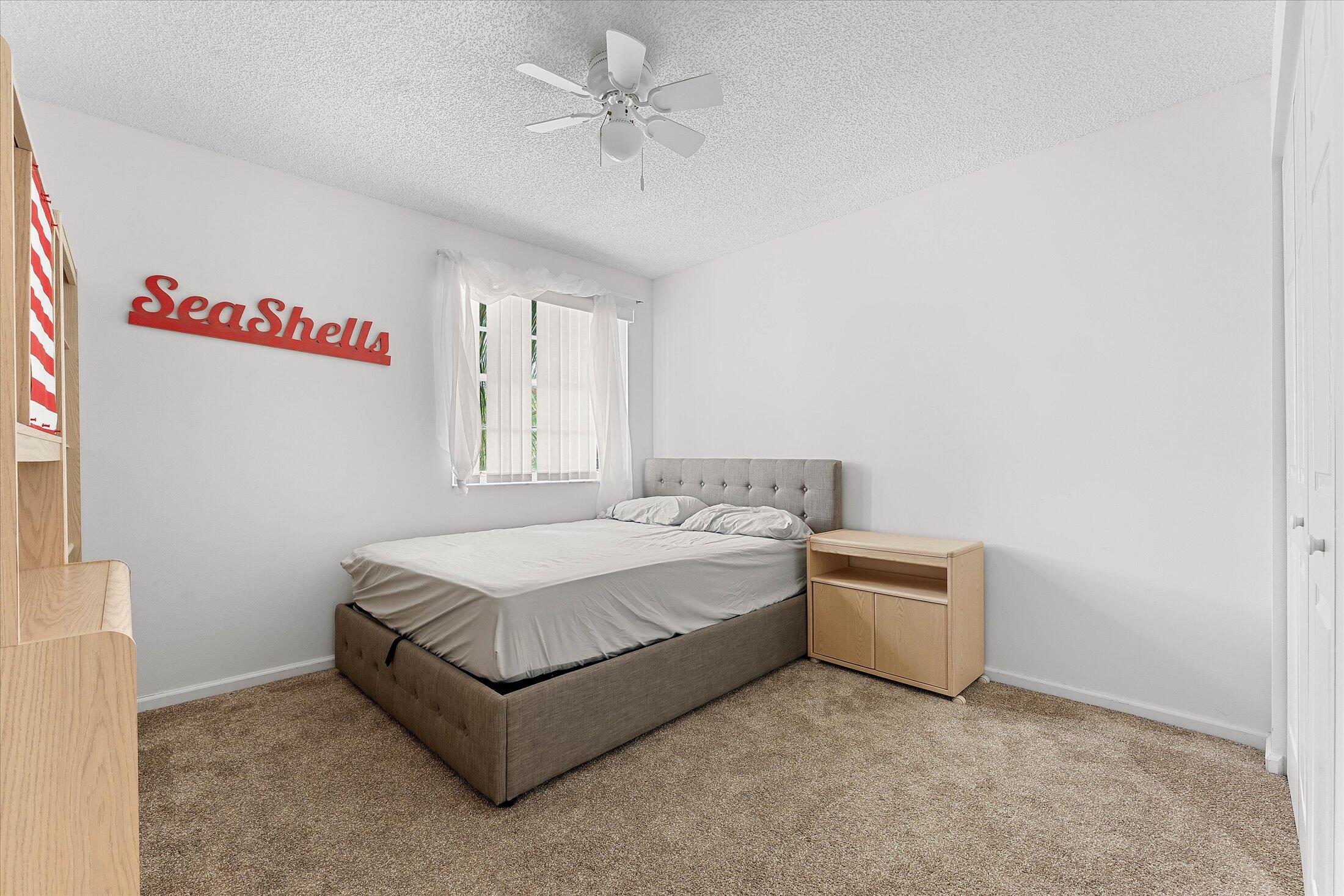 7061 Chesapeake Circle Boynton Beach, FL 33436 - Photo 32 of 51 a spacious bedroom with a bed and a chandelier