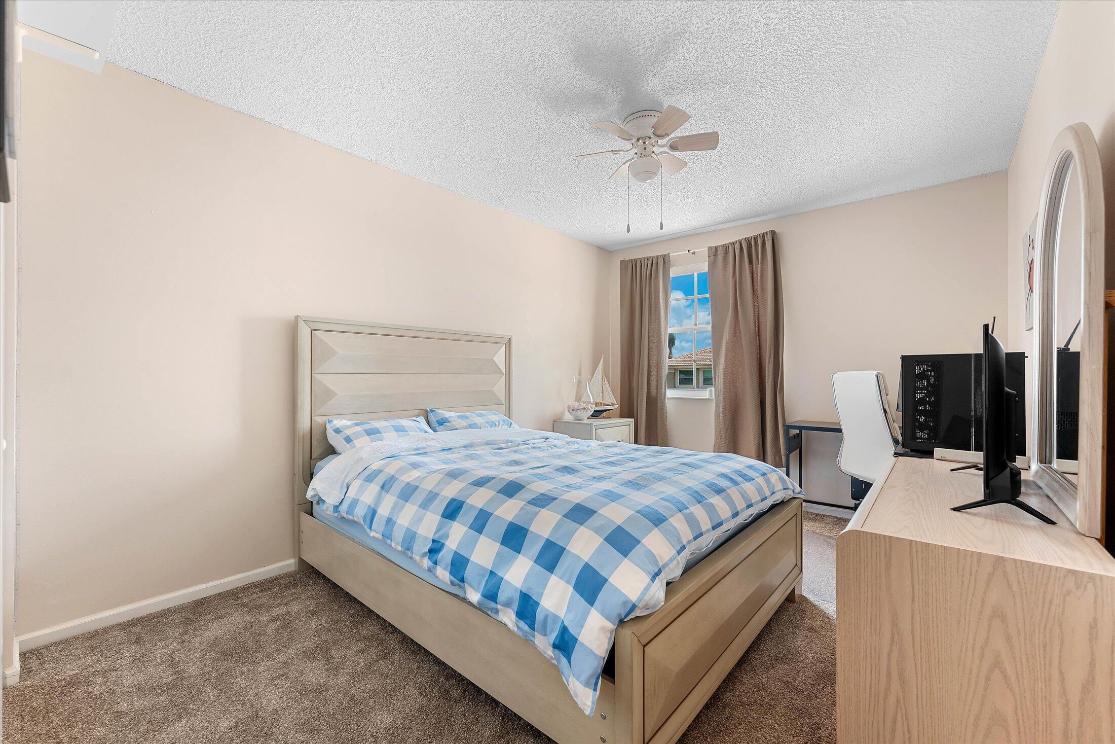 7061 Chesapeake Circle Boynton Beach, FL 33436 - Photo 35 of 51 a bedroom with a bed and a flat tv screen on a dresser