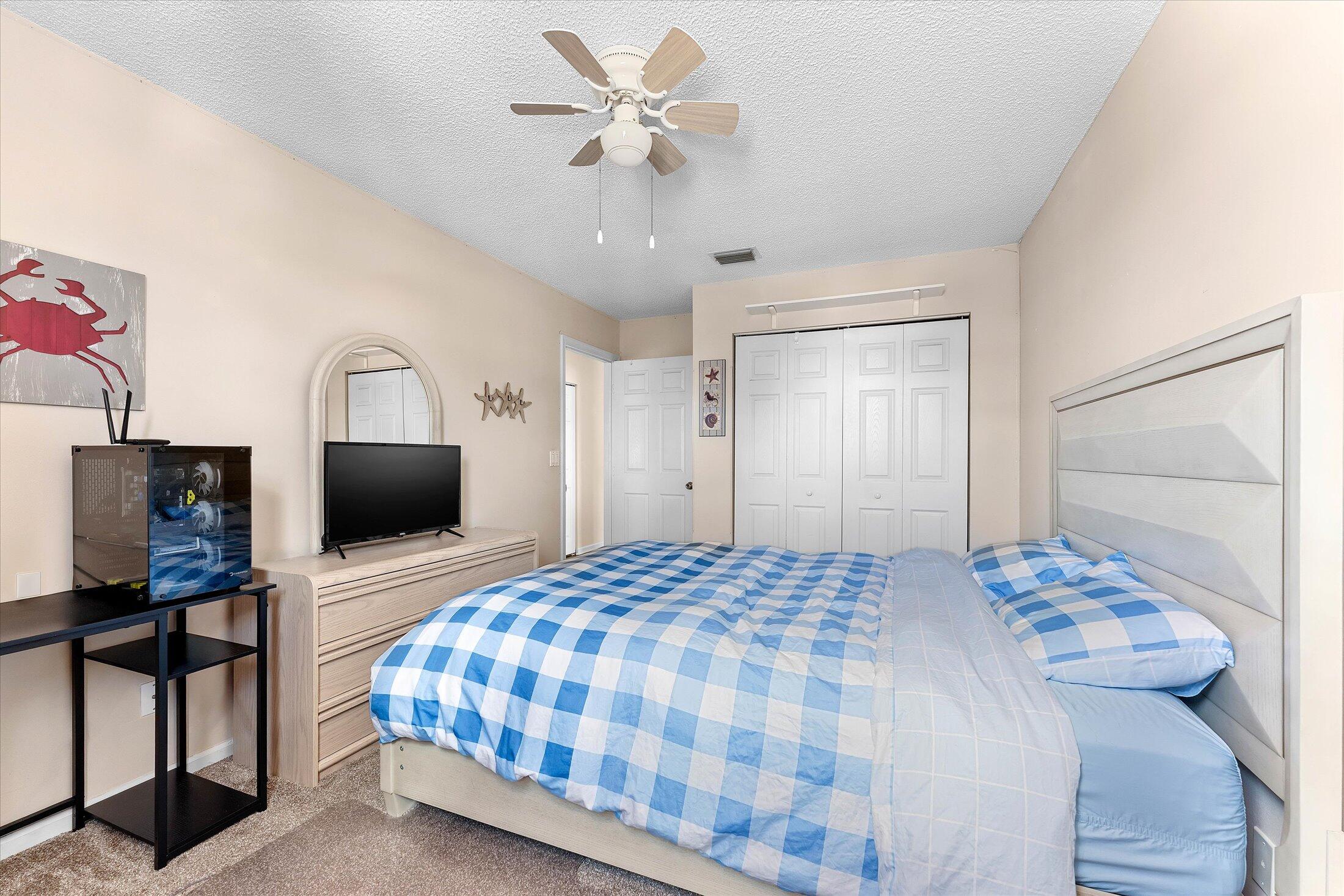 7061 Chesapeake Circle Boynton Beach, FL 33436 - Photo 36 of 51 a bedroom with a bed a dresser and a chandelier