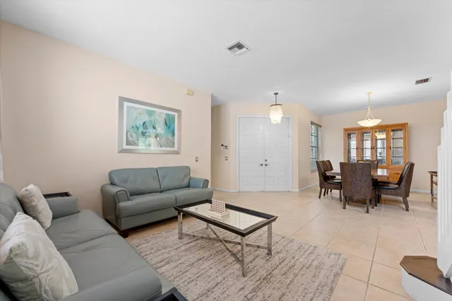 a living room with furniture and a dining table with kitchen view
