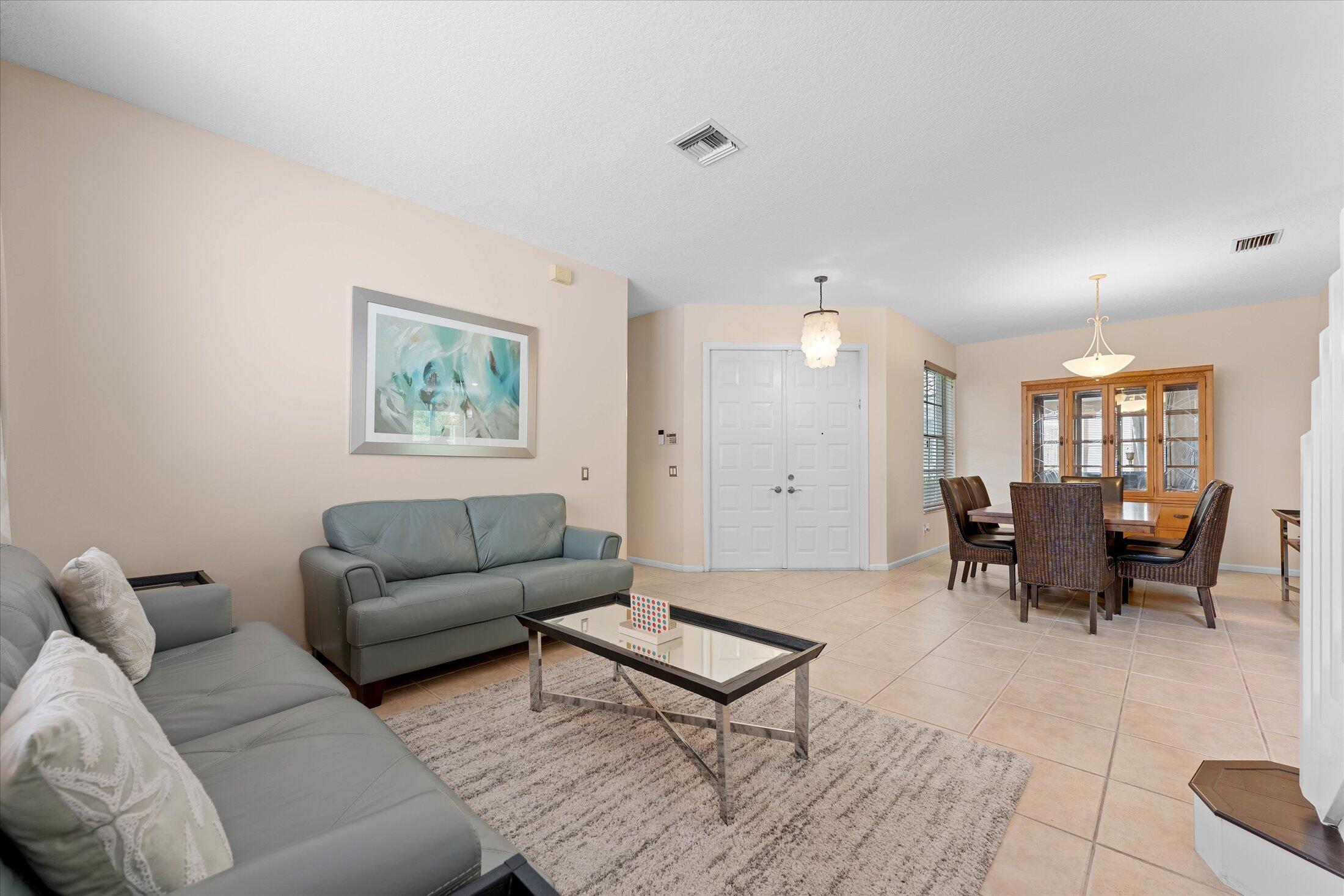 7061 Chesapeake Circle Boynton Beach, FL 33436 - Photo 5 of 51 a living room with furniture and a dining table with kitchen view