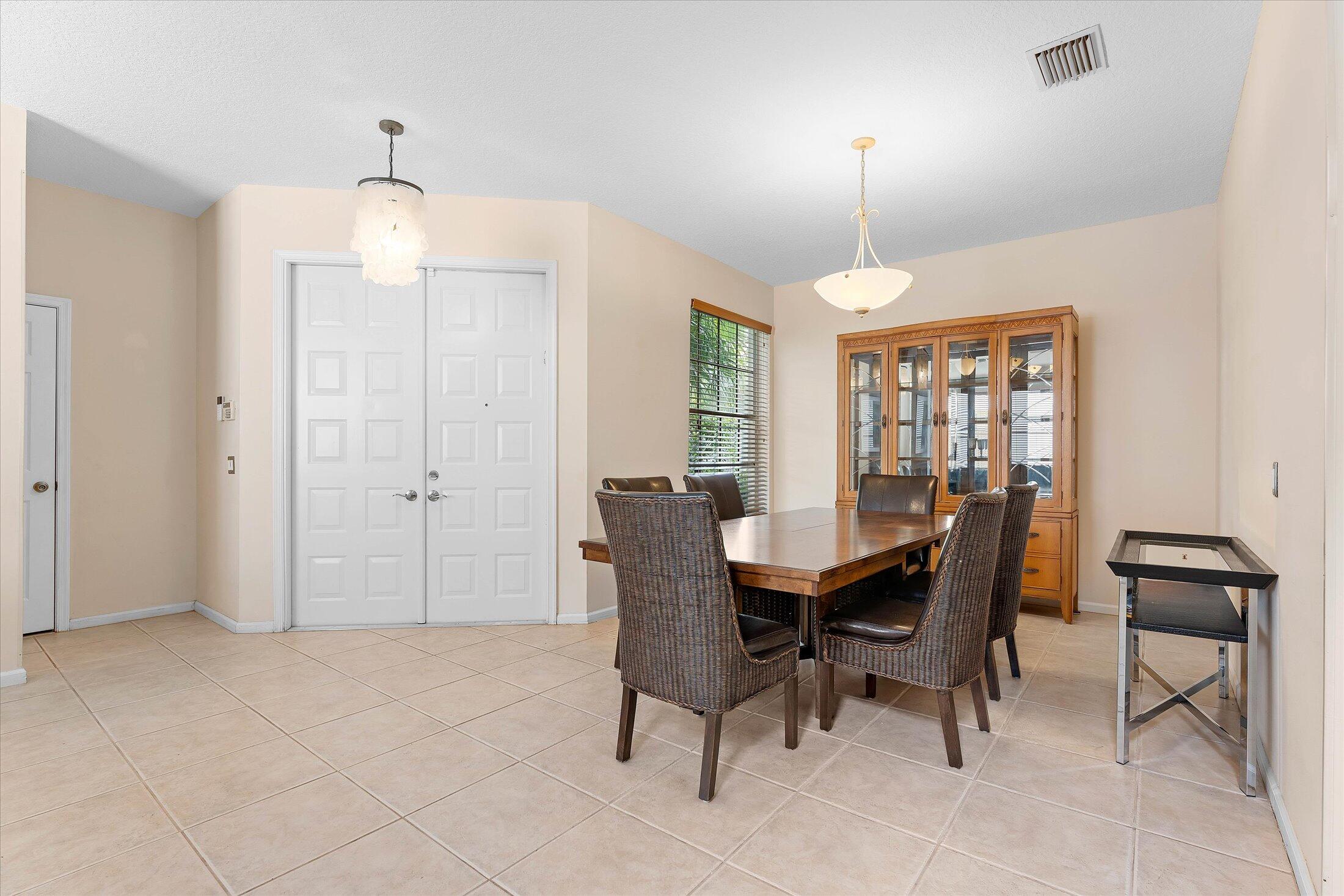 7061 Chesapeake Circle Boynton Beach, FL 33436 - Photo 7 of 51 a dining room with furniture a chandelier and window