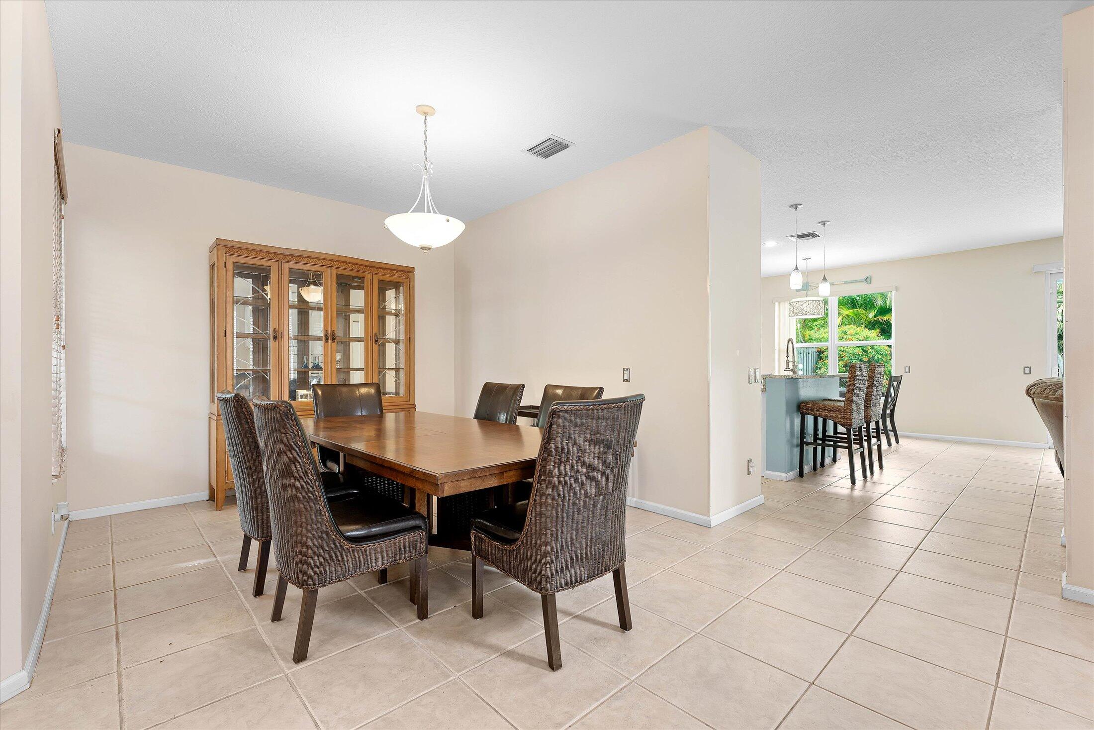 7061 Chesapeake Circle Boynton Beach, FL 33436 - Photo 8 of 51 a dining room with furniture a chandelier and window