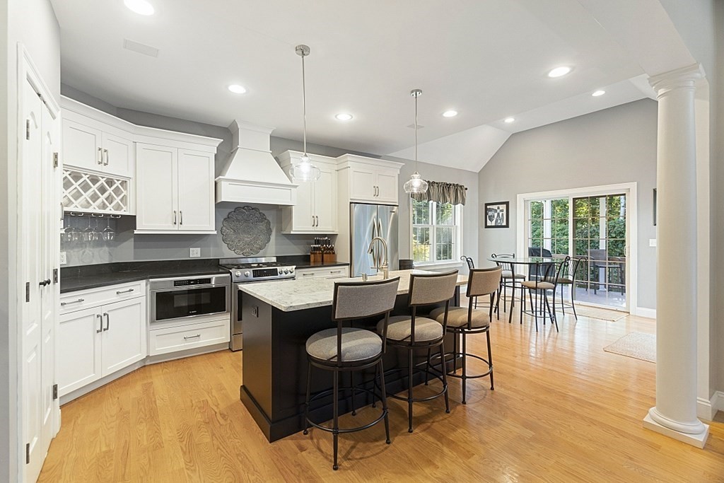 3 Squareshire Road Sterling, MA 01564 - Photo 12 of 42 a kitchen with stainless steel appliances granite countertop a stove top oven a sink dishwasher a dining table and chairs with wooden floor