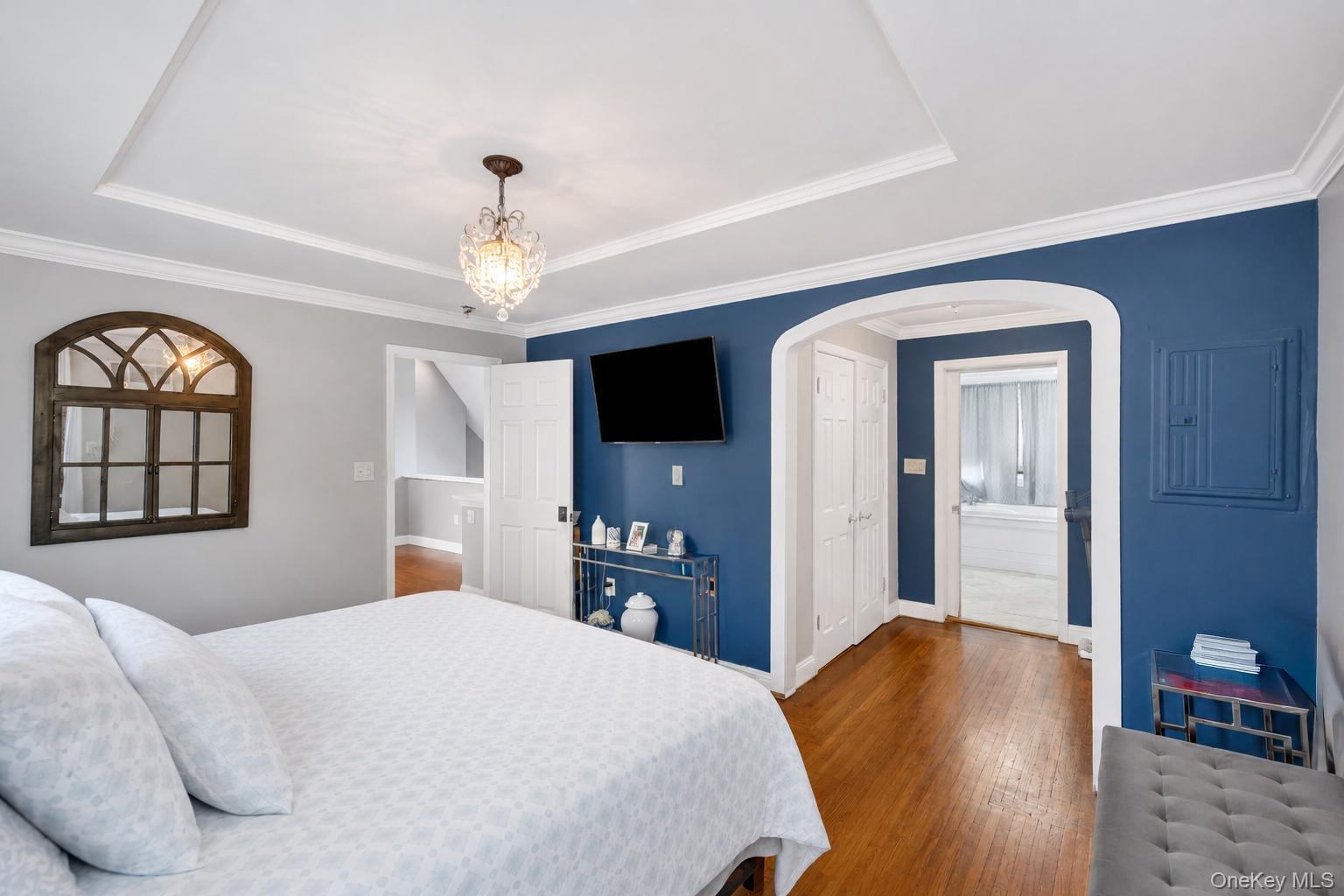 19 Joan Road Bay Shore, NY 11706 - Photo 25 of 50 Bedroom featuring wood-finish flooring, a tray ceiling, and crown molding