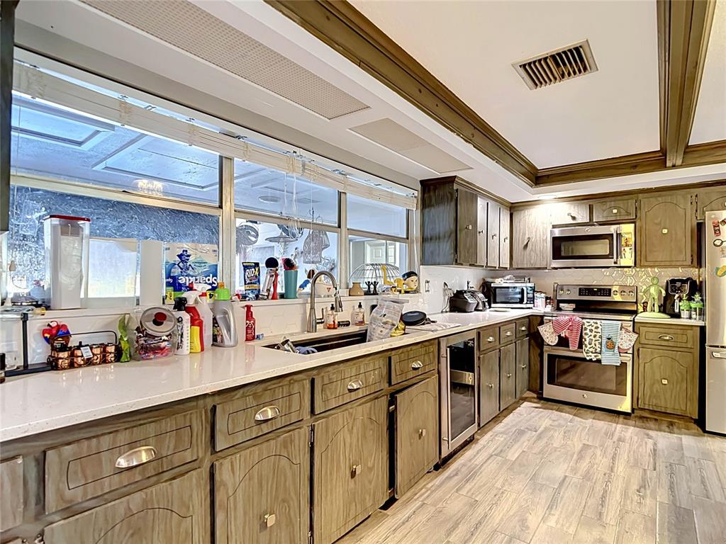 5433 Front Drive Holiday, FL 34690 - Photo 6 of 68 a kitchen with stainless steel appliances sink stove microwave and cabinets