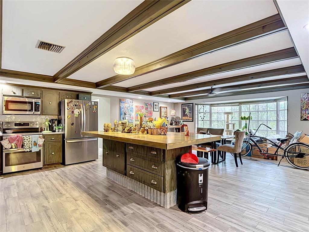 5433 Front Drive Holiday, FL 34690 - Photo 7 of 68 a kitchen with lots of wooden furniture and stainless steel appliances