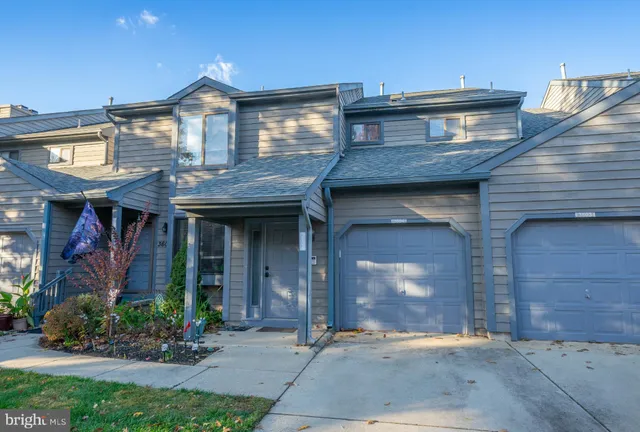 a view of a brick house with potted plants and a table and chairs