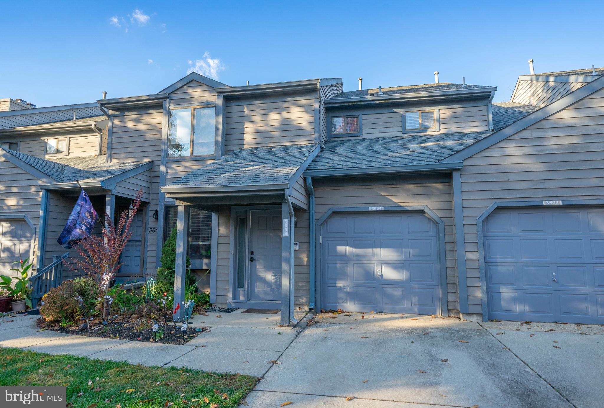a view of a brick house with potted plants and a table and chairs
