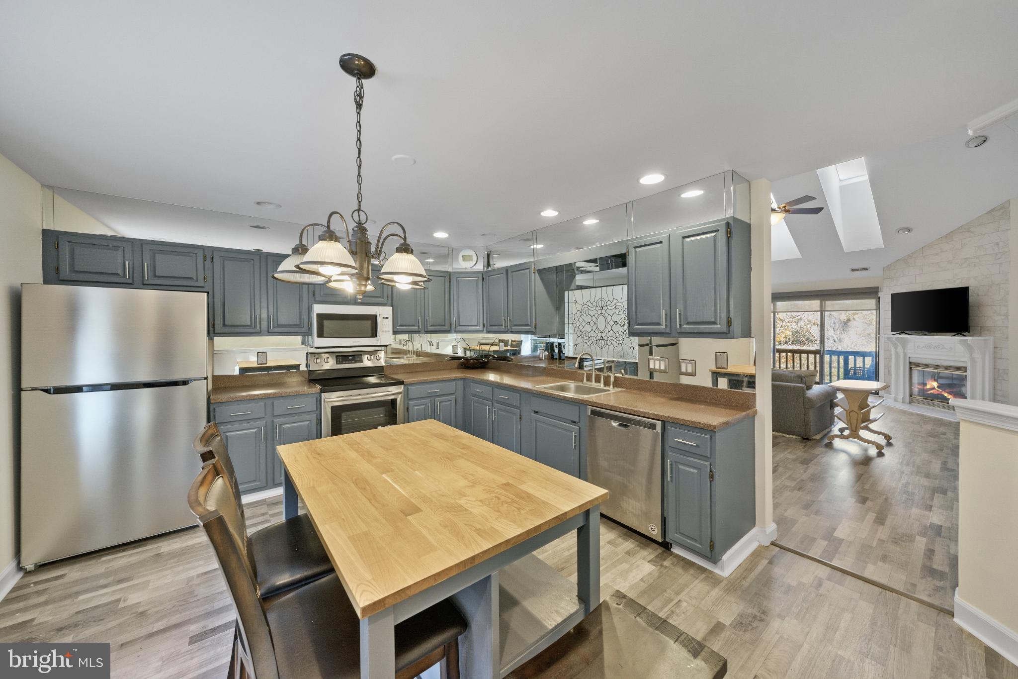 3604B Chadbury Road Mount Laurel, NJ 08054 - Photo 3 of 28 a kitchen with stainless steel appliances granite countertop a refrigerator a sink dishwasher a stove and a dining table with wooden floor
