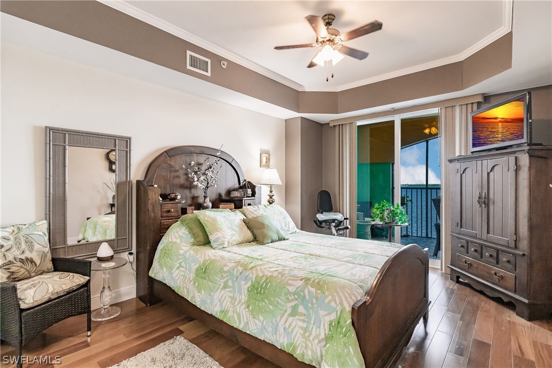2797 First Street, Unit 403 Fort Myers, FL 33916 - Photo 19 of 33 a bedroom with a bed and a chandelier