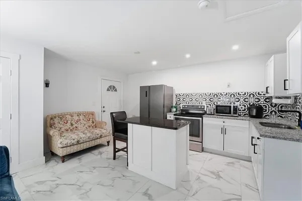 a kitchen with a sink and chairs