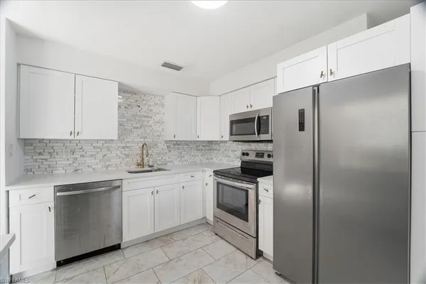 a kitchen with a sink stainless steel appliances and cabinets