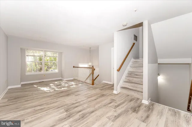a view of a livingroom with wooden floor and stairs