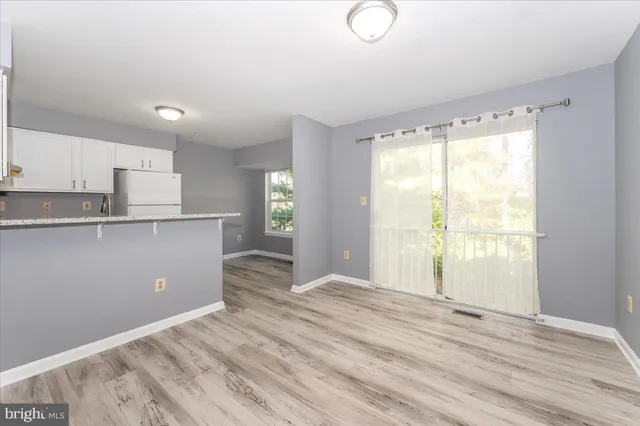 a view of a kitchen with wooden floor and a window