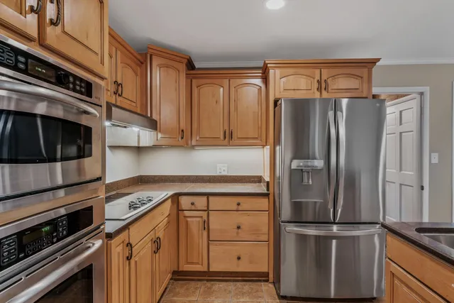 a kitchen with stainless steel appliances a refrigerator sink and microwave