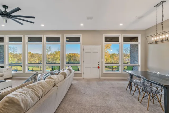 a living room with furniture and a large window with garden view
