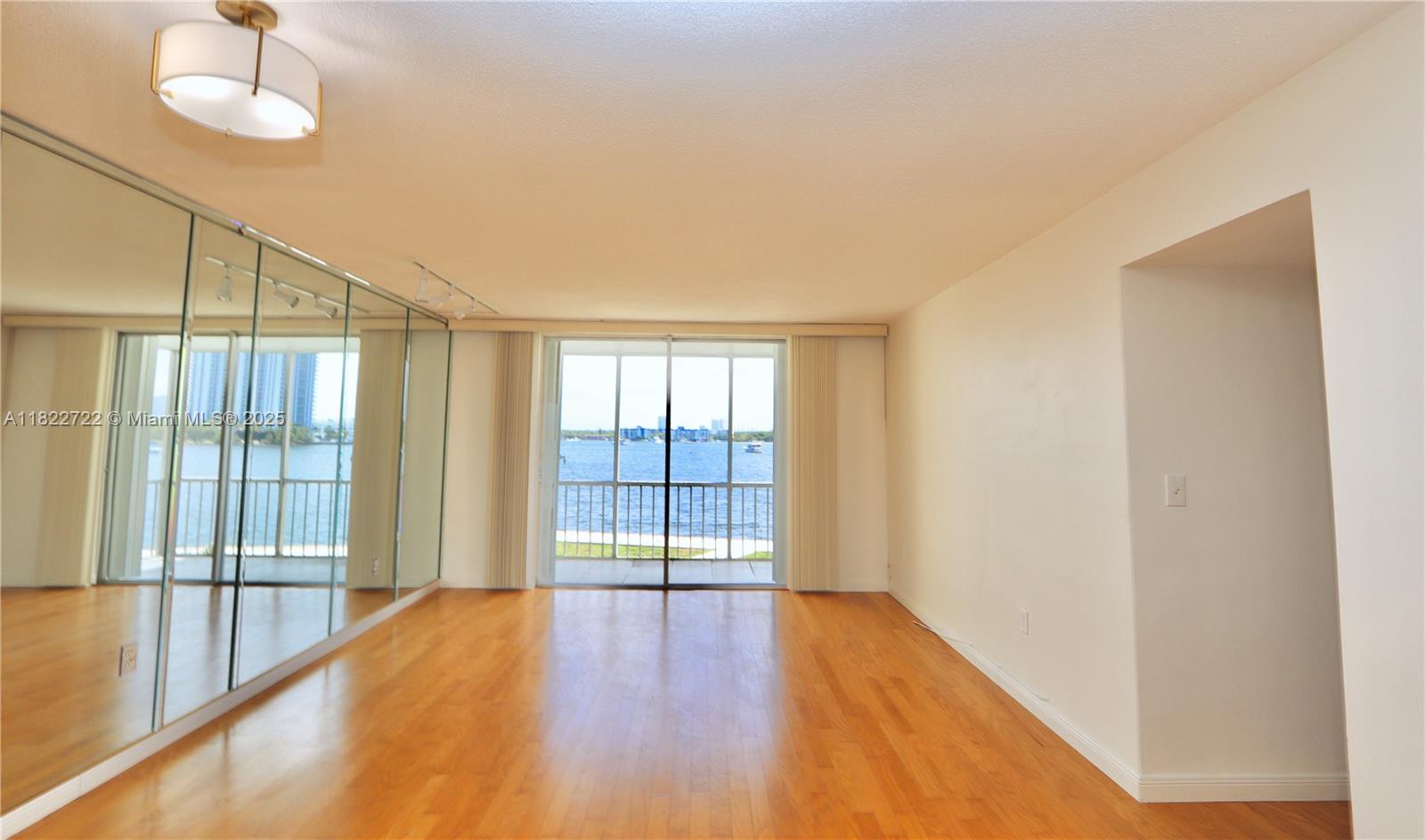 2920 Point E Drive, Unit N208 Aventura, FL 33160 - Photo 12 of 34 a view of an empty room with a window and wooden floor