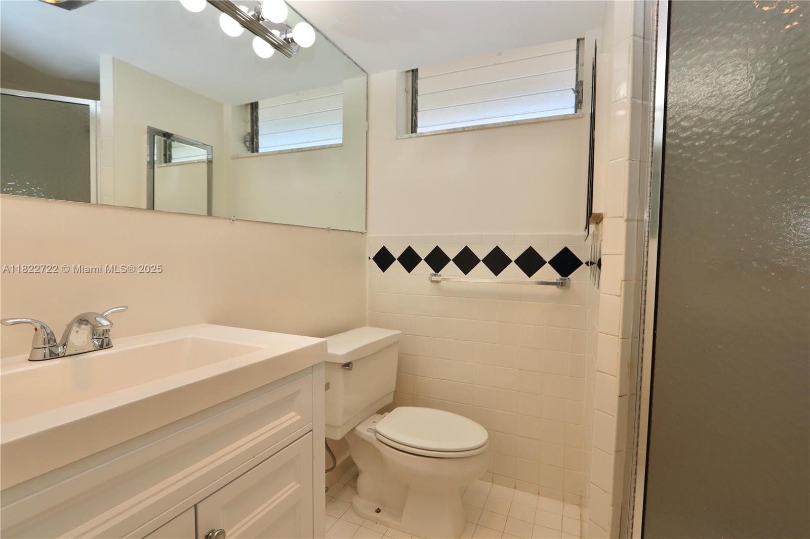 2920 Point E Drive, Unit N208 Aventura, FL 33160 - Photo 17 of 34 a bathroom with a sink a toilet and a mirror