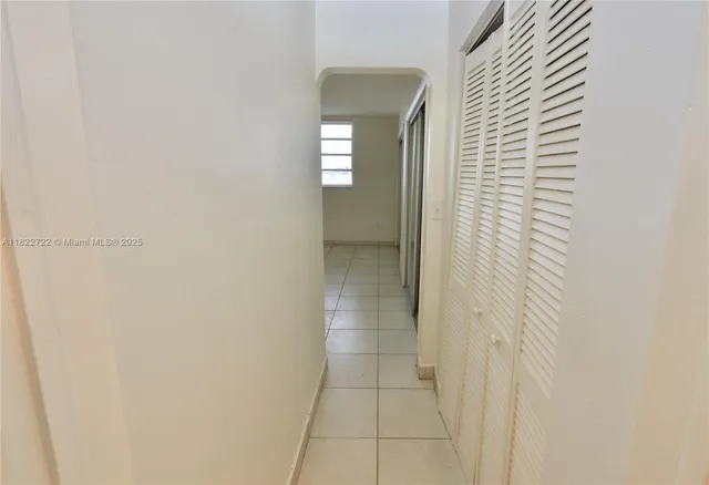 a hallway with wooden floor and a potted plant