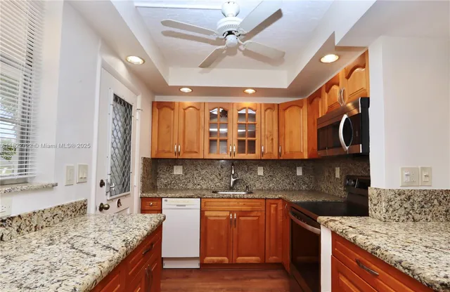 a kitchen with stainless steel appliances granite countertop wooden cabinets and a granite counter tops